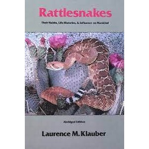 Rattlesnakes book cover showing two coiled rattlesnakes among rocks and pink flowers.