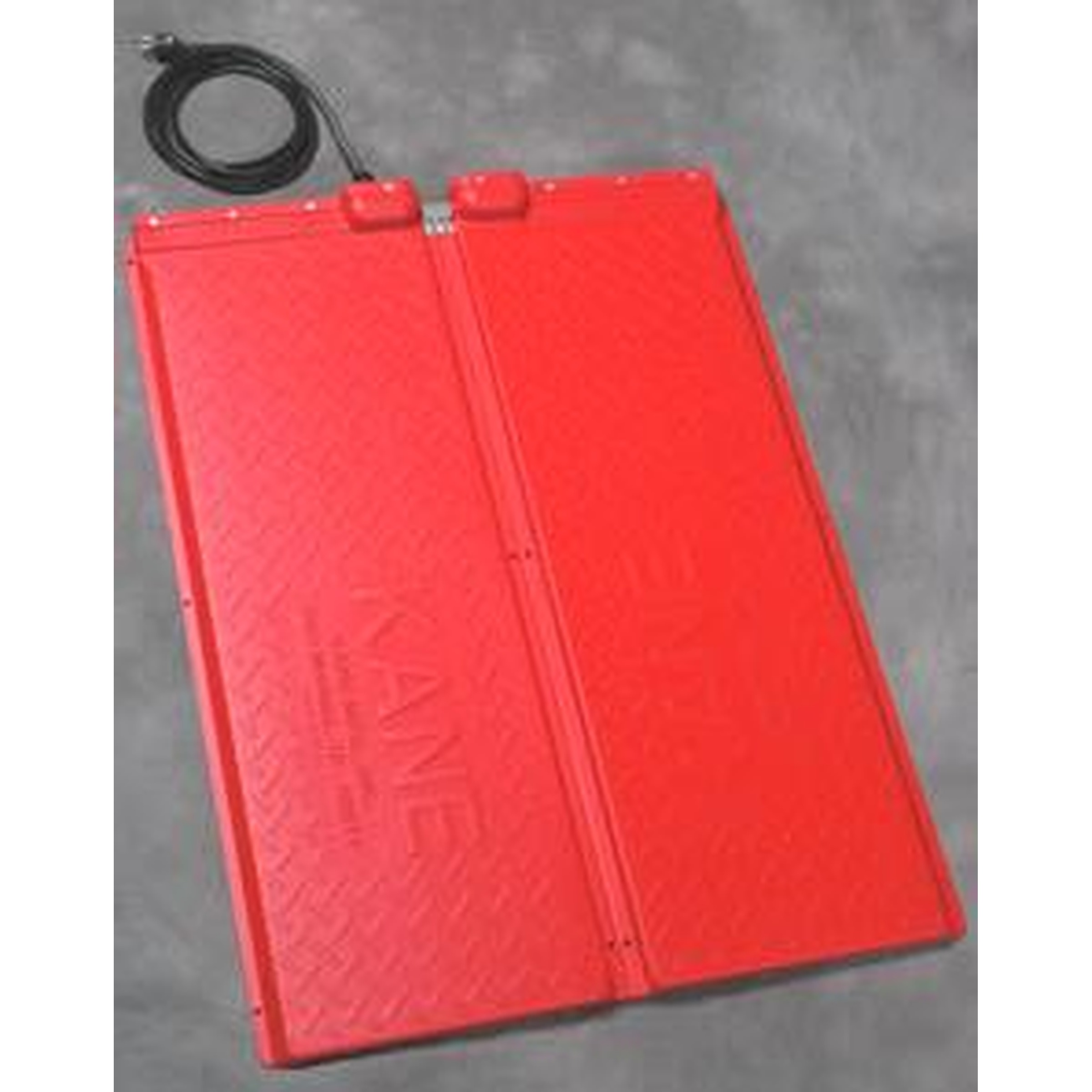 Two red rectangular battery packs with a black cord on a gray surface.