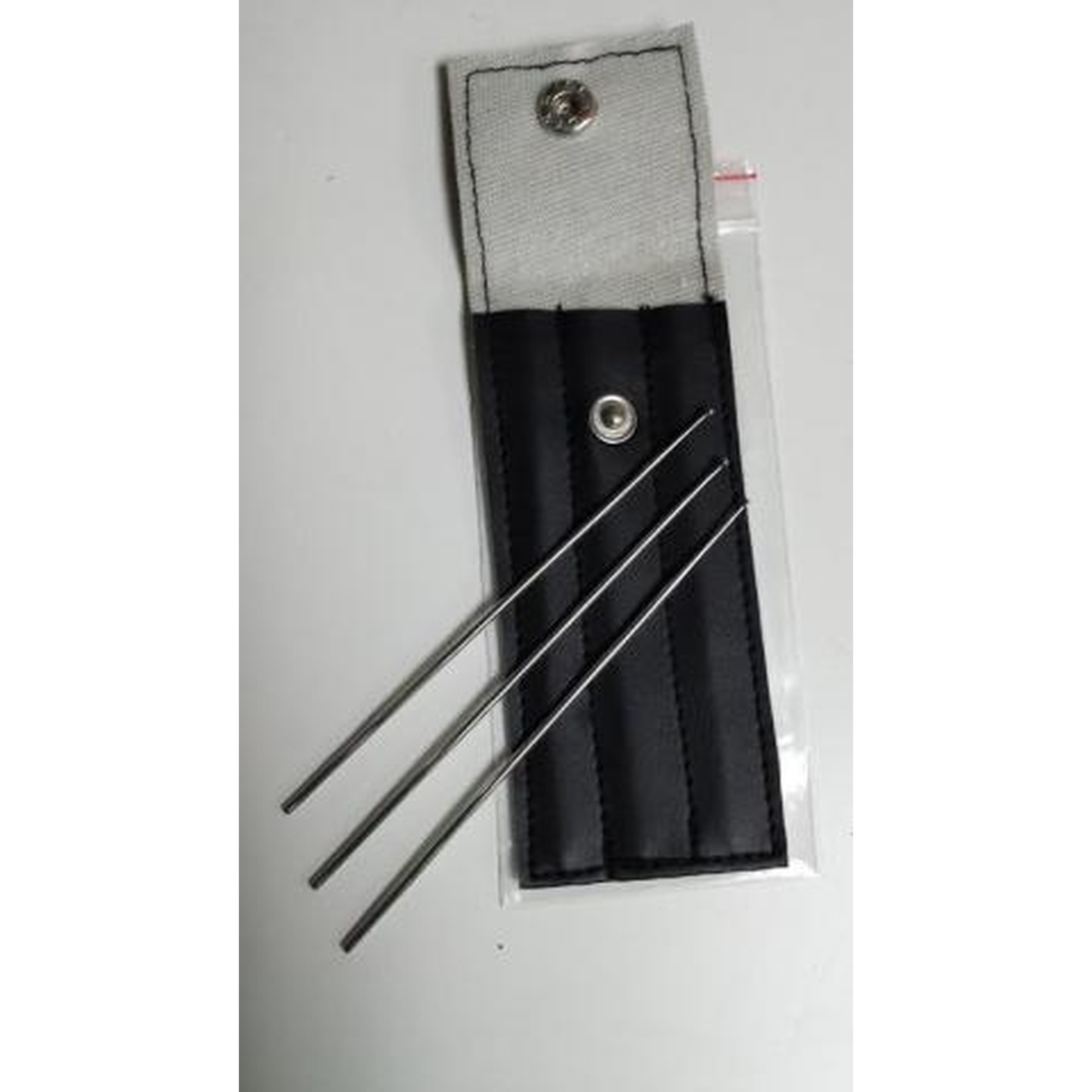 Gray fabric roll with a black padded pocket holding four long thin metal needles and a snap-button closure.