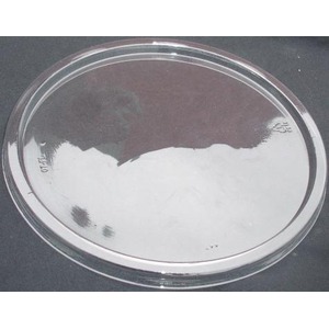 Shiny round metal petri dish on a dark background with reflections.