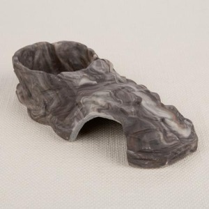 Gray carved stone with a curved arch opening and textured ridges.