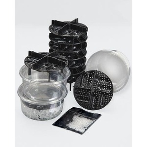 Multi-piece herb grinder with stacked black discs, clear grinding chamber, and kief tray with powder.