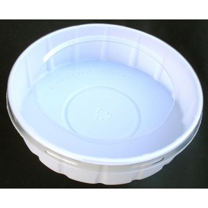 Top view of a white plastic bottle cap on a dark surface.