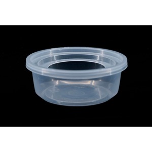 Transparent round plastic container with a ridged rim, empty