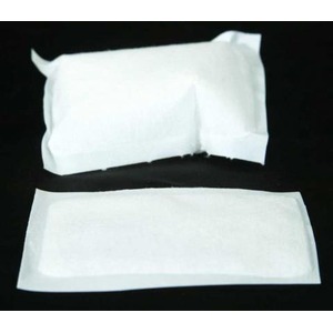 Two white rectangular sachets on a black surface.