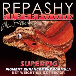 Close-up of a red-orange reptile (frog) on a black background with Repashy Superfoods Superpig pigment enhancement label.