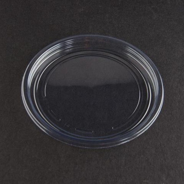 clear round plastic lid on a dark surface, top view