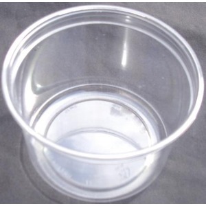 Clear glass cup viewed from above, empty, on dark fabric background.