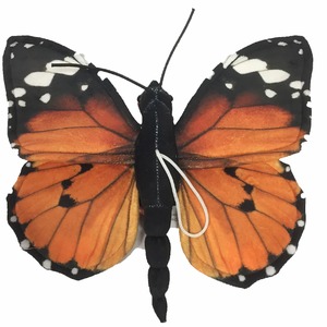 Fabric orange-black butterfly with white spots; string looped around its black body.