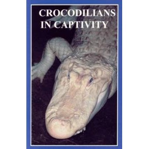 Close-up of a crocodile's head in captivity, with bold Crocodilians in Captivity on a dark background.