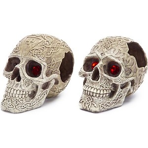 Two intricately carved skulls with Celtic patterns and red gem eyes.