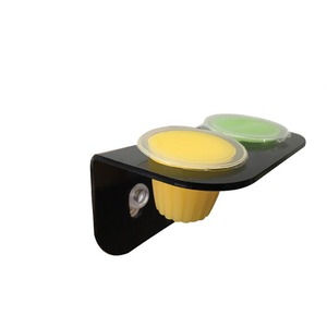 Black wall-mounted bracket with two round yellow and green caps on top and a yellow gear-like knob beneath, plus a recessed screw.