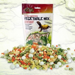 Bag labeled "Reptile Mummies Vegetable Mix" behind a colorful pile of chopped vegetables and round white balls.