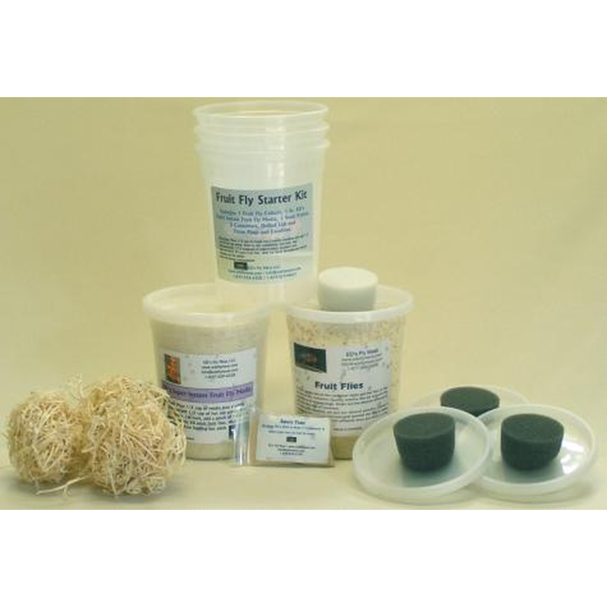 Fruit fly starter kit with labeled jars, tubes, two natural fiber balls, and a plate with green stoppers.