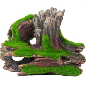 Weathered driftwood sculpture covered in bright green moss, featuring arches, a hollow cavity and tunnel.