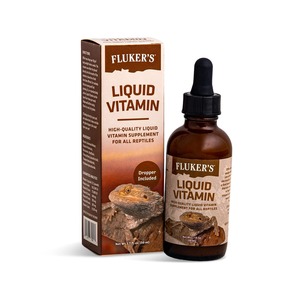 Fluker's Liquid Vitamin bottle with dropper beside a brown box featuring a reptile photo.
