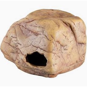 Rounded beige rock with a dark hollow hole on its side.