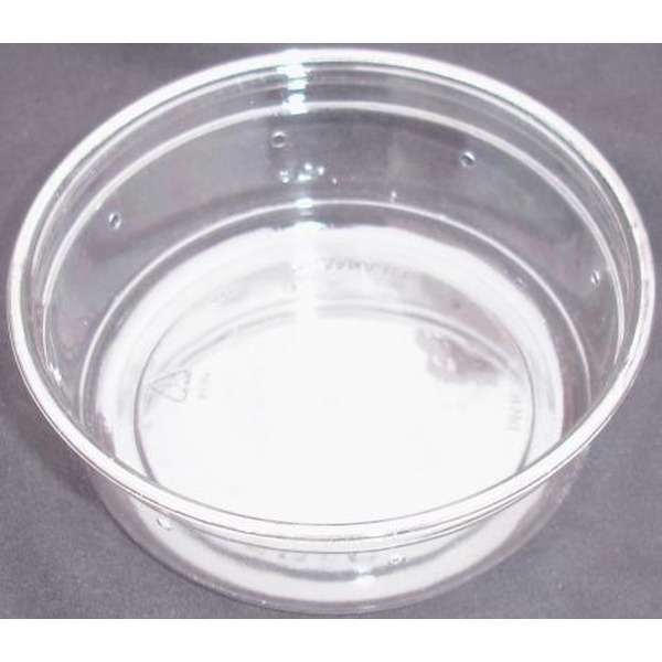 Clear glass bowl on a gray surface, empty with reflections and light highlights.